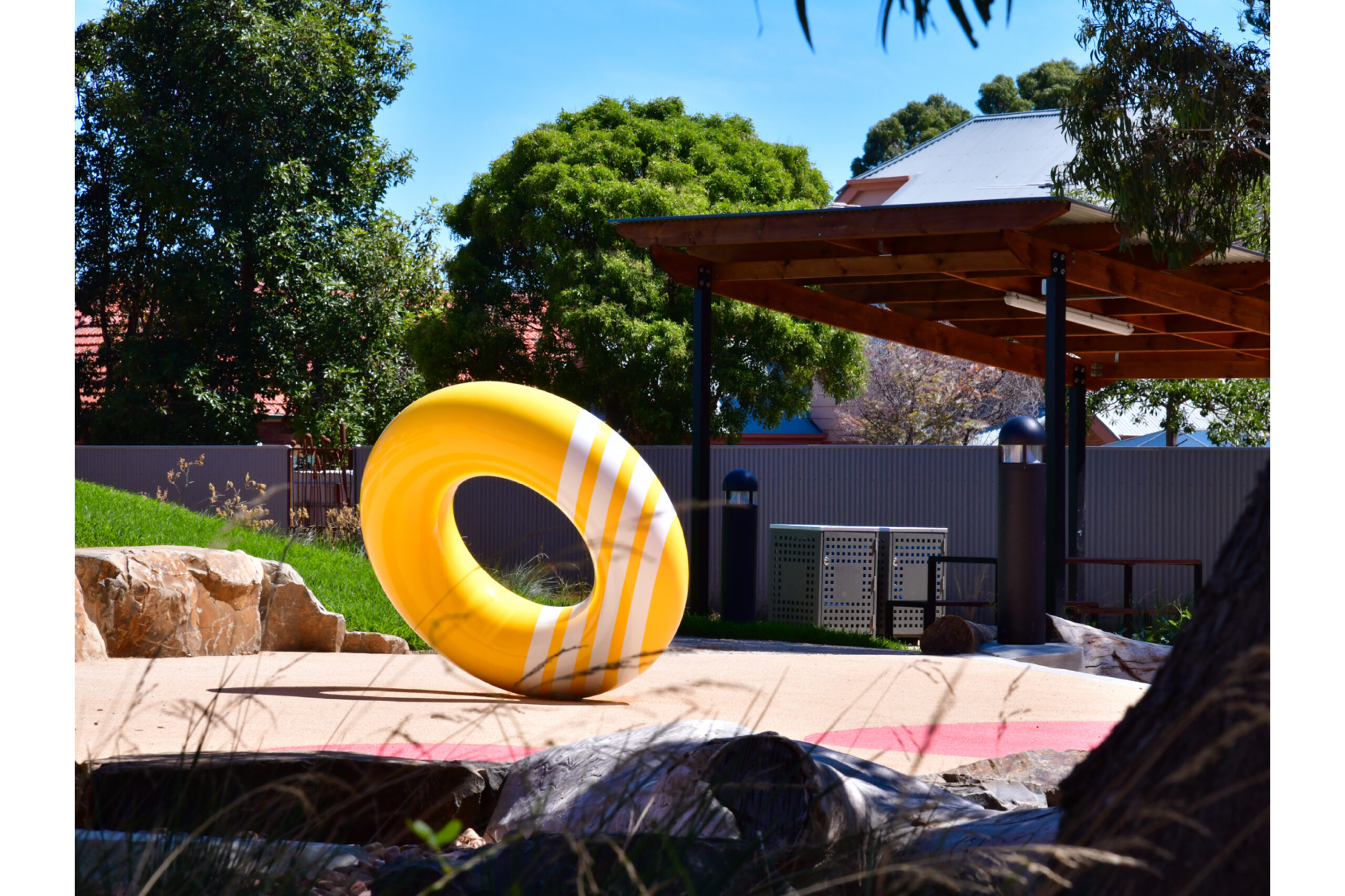 Image of a yellow, donut-shaped play sculpture, "The Third Quarter".