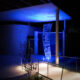 Vivid blue lighting highlights a curved semi-transparent sculpture
